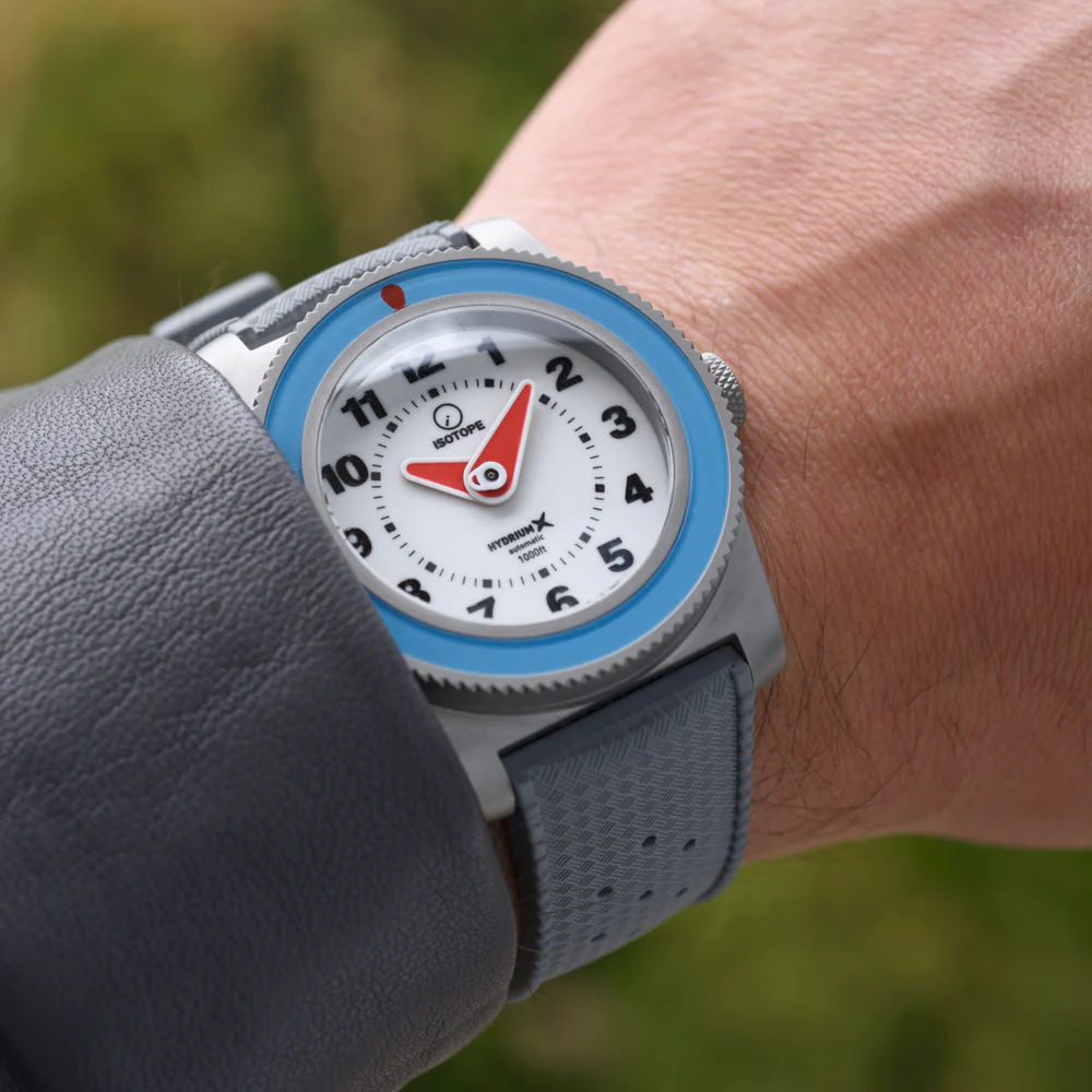 Isotope Hydrium watch with a white dial and blue bezel, worn on the wrist