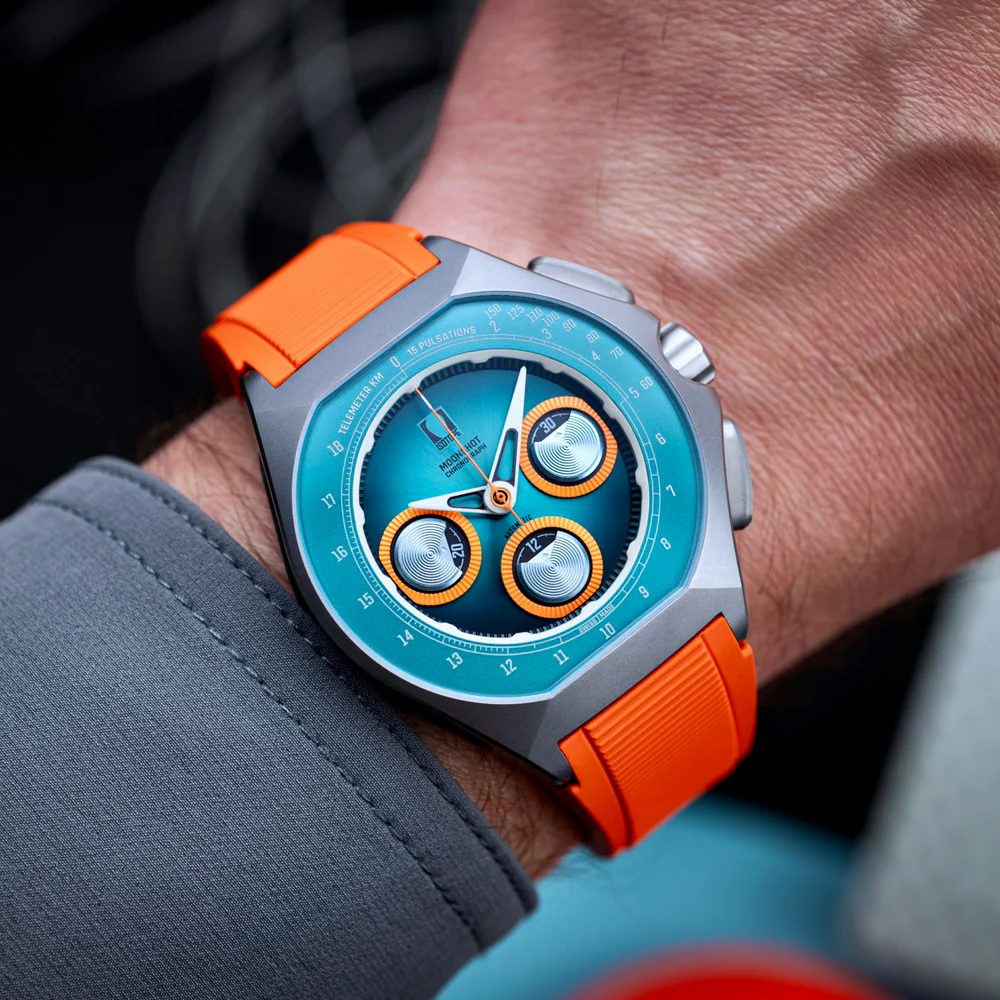 Isotope Moonshot Chronograph with teal dial and orange strap, worn on the wrist
